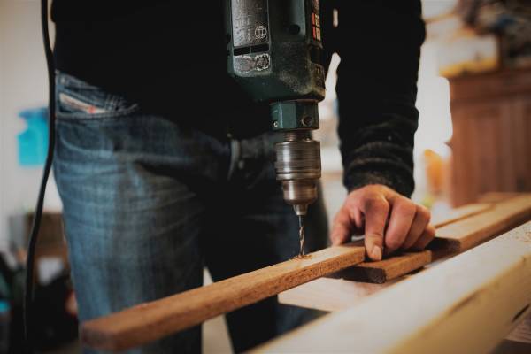 a home repair man drilling into wood