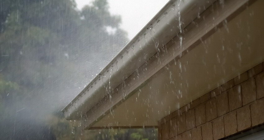 water overflowing out of a gutter with not enough downspouts